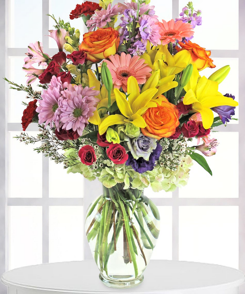 A clear vase filled with pastels and brights from roses, daisies, lilies, hydrangeas and so much more.   Vase and/or flower variety will vary depending on availability. Arrangement will be as close as possible, but may not be exact.