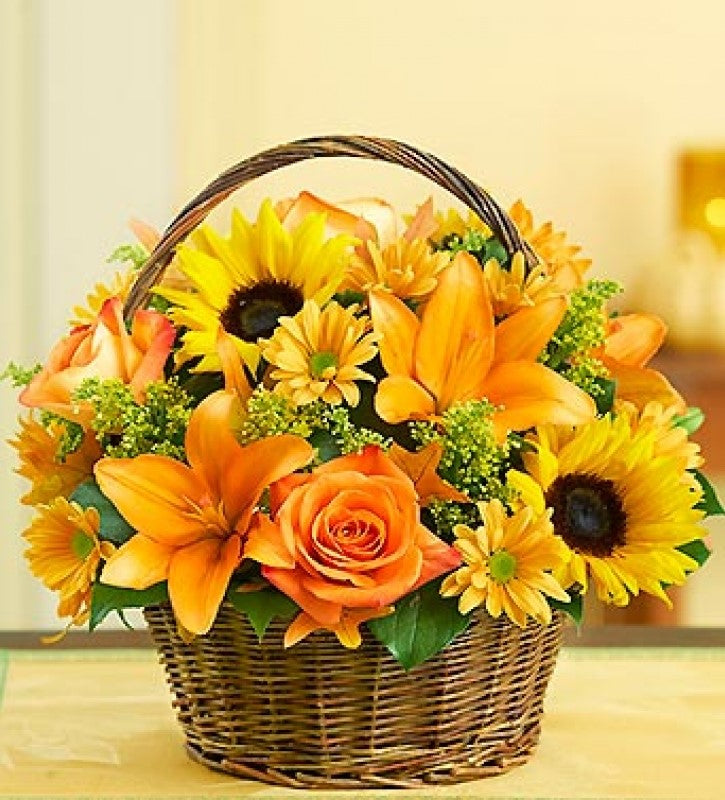  Richly colored roses, sunflowers, lilies, oak leaves and more are gathered in a basket.   Basket and/or flower variety will vary depending on availability. Arrangement will be as close as possible, but may not be exact.