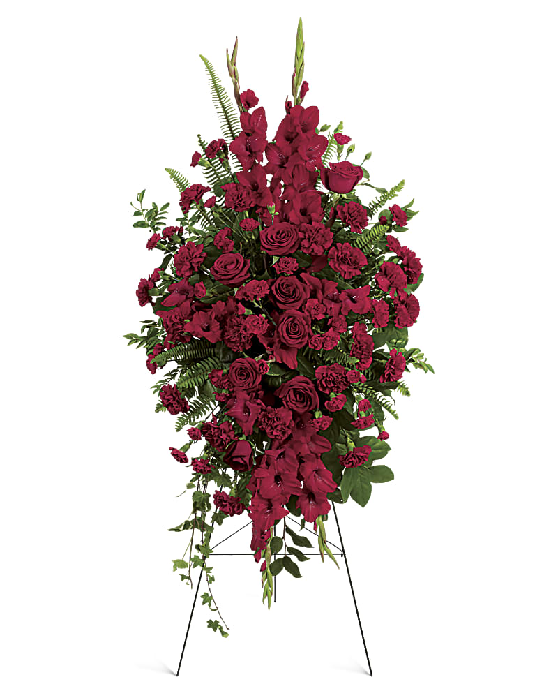 A standing spray created out of all red assorted flowers.   Flower variety will vary depending on availability. Arrangement will be as close as possible, but may not be exact. 