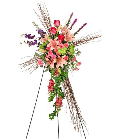 Twigs are tied together to make this beautiful cross with assorted pink, purple and green flowers arranged in the center.   Flower variety will vary depending on availability. Arrangement will be as close as possible, but may not be exact.