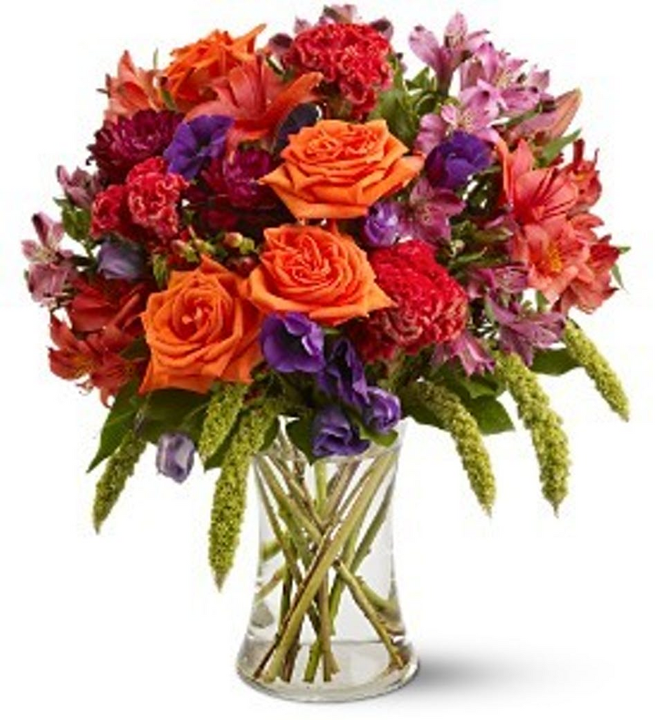 Fall colors of orange, purples and reds tightly combined in a clear glass vase.   Vase and/or flower variety will vary depending on availability. Arrangement will be as close as possible, but may not be exact. 